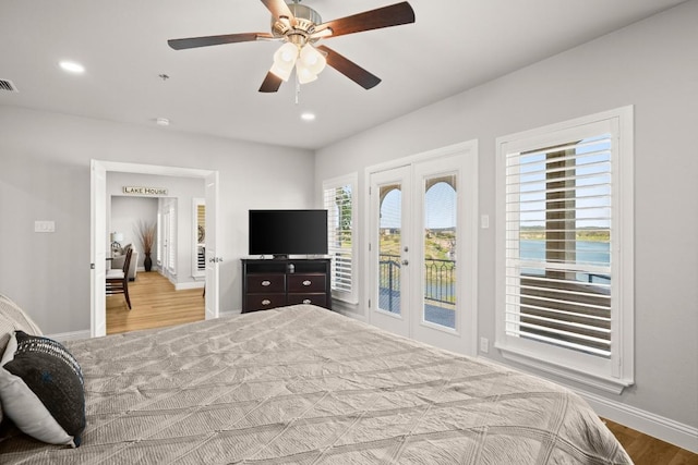 bedroom featuring wood finished floors, baseboards, visible vents, french doors, and access to outside