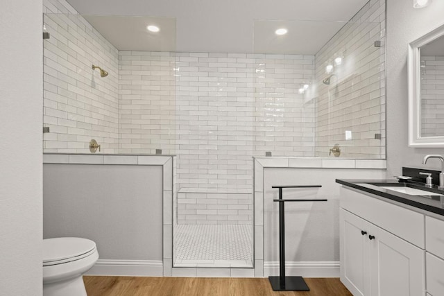 full bath featuring a walk in shower, toilet, recessed lighting, wood finished floors, and vanity