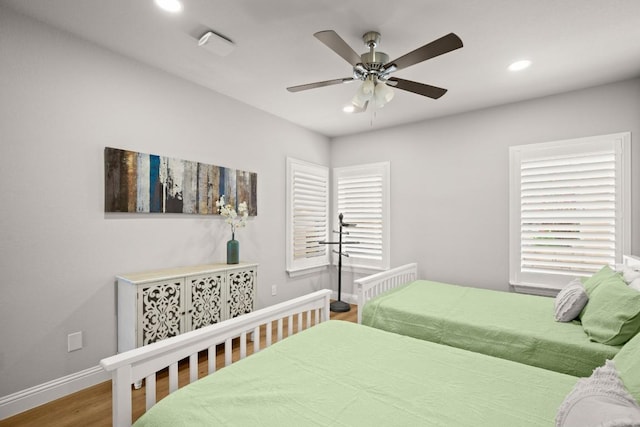 bedroom featuring recessed lighting, multiple windows, baseboards, and wood finished floors