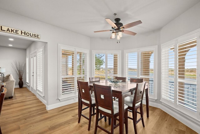 dining room featuring a ceiling fan, light wood-type flooring, and baseboards