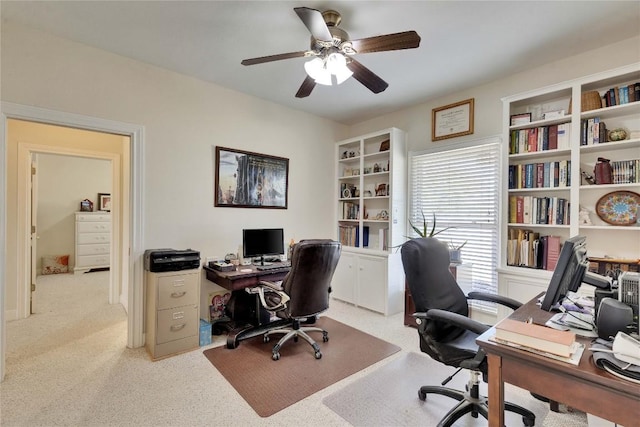 office space featuring a ceiling fan and light carpet