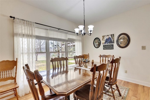 dining space with light wood-style floors, baseboards, and a chandelier