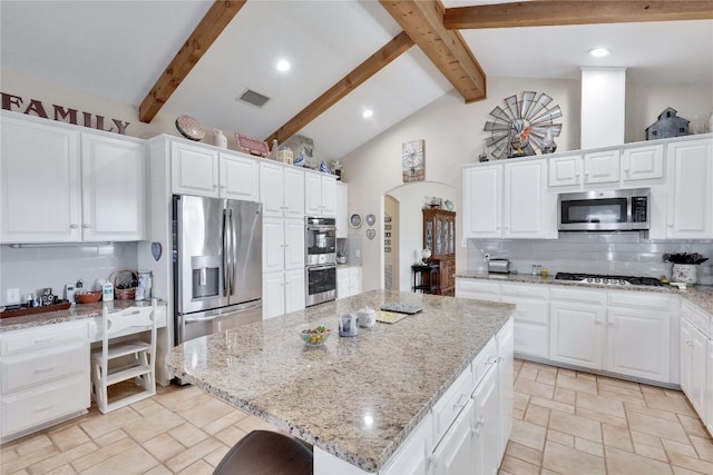 kitchen featuring visible vents, arched walkways, backsplash, and appliances with stainless steel finishes