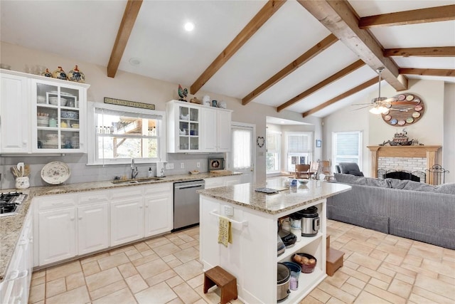 kitchen with backsplash, open floor plan, a fireplace, stainless steel appliances, and a sink