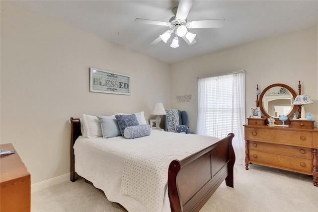 bedroom with light carpet, a ceiling fan, and baseboards