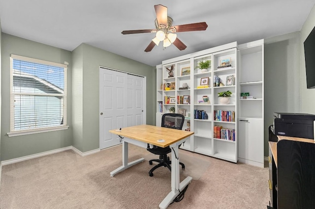 office with light colored carpet, a ceiling fan, and baseboards