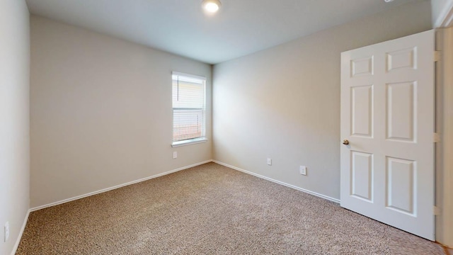 unfurnished room with carpet and baseboards