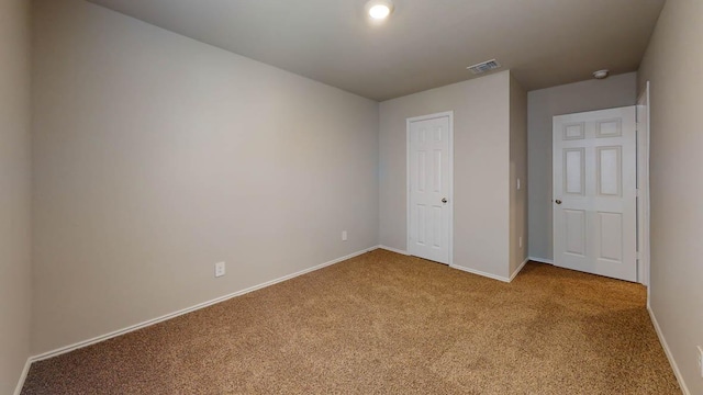 unfurnished bedroom with visible vents, carpet flooring, and baseboards