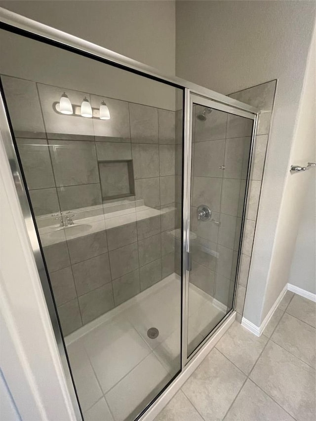 full bathroom featuring tile patterned floors, a stall shower, and baseboards