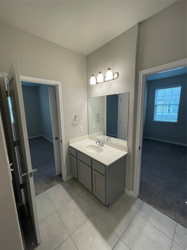 bathroom featuring tile patterned floors, baseboards, and vanity