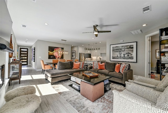 living area featuring recessed lighting, visible vents, and wood finish floors