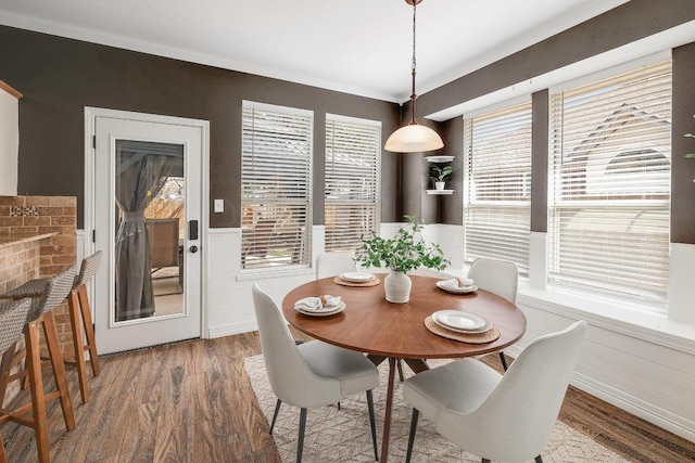 dining area with wainscoting and wood finished floors