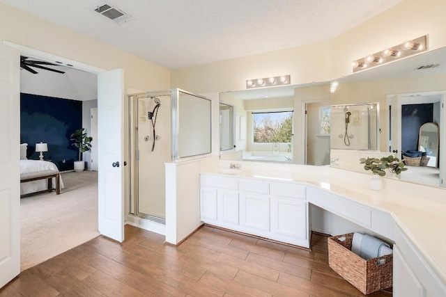 bathroom with visible vents, a shower stall, ceiling fan, ensuite bathroom, and wood finished floors