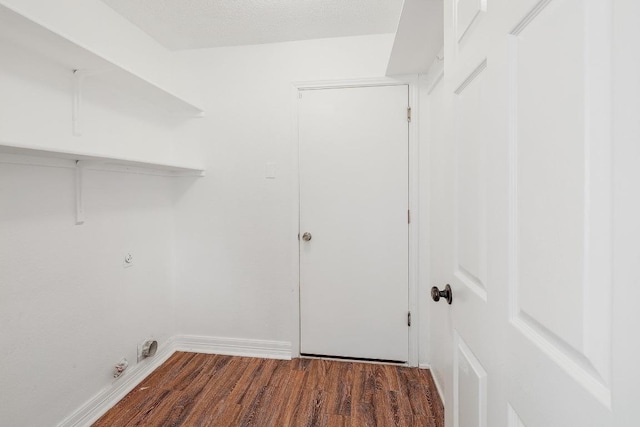 clothes washing area with laundry area, gas dryer hookup, baseboards, and wood finished floors