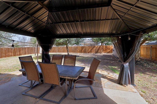 view of patio / terrace with a gazebo, outdoor dining area, and a fenced backyard