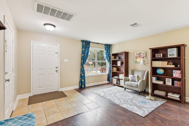 entrance foyer with visible vents, baseboards, and wood finished floors