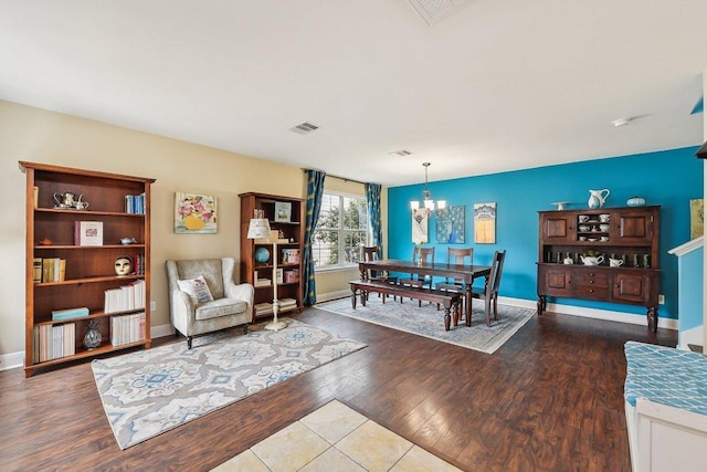 dining space featuring an inviting chandelier, wood finished floors, visible vents, and baseboards