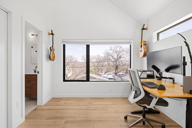 home office with lofted ceiling, light wood-style floors, and a sink