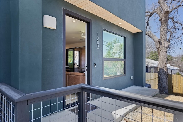 entrance to property with fence and stucco siding