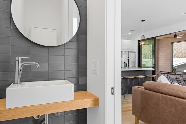 bathroom with wood finished floors, recessed lighting, and a sink