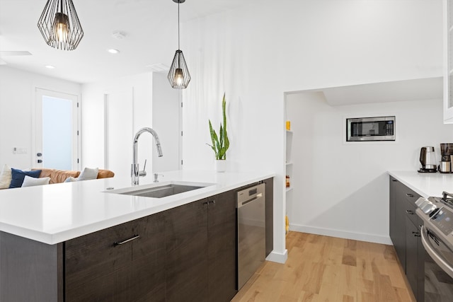 kitchen with a sink, stainless steel appliances, modern cabinets, and dark brown cabinets