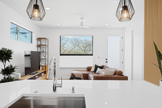 interior space featuring a sink, decorative light fixtures, recessed lighting, and light countertops