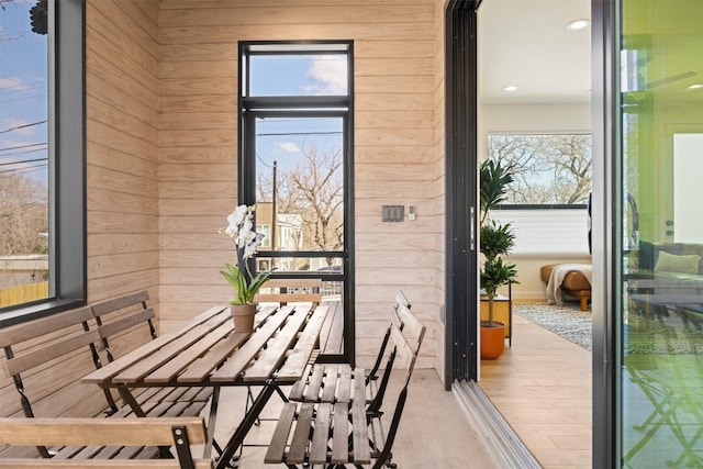 doorway to outside with wooden walls and wood finished floors
