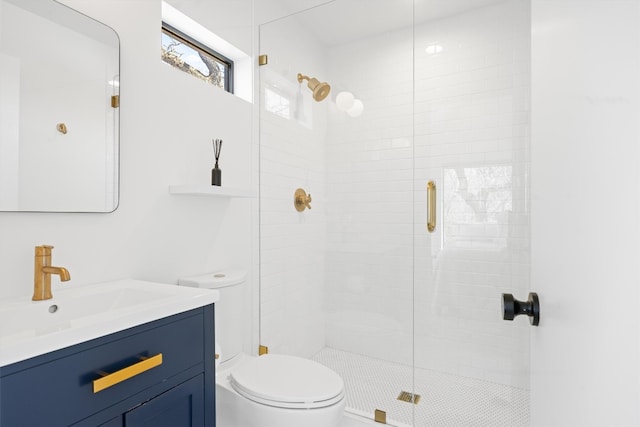 bathroom with toilet, a stall shower, and vanity