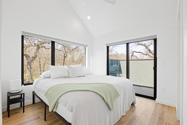 bedroom with light wood finished floors, high vaulted ceiling, baseboards, and access to outside