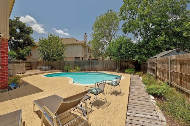 view of pool featuring a fenced in pool, a fenced backyard, and a patio area