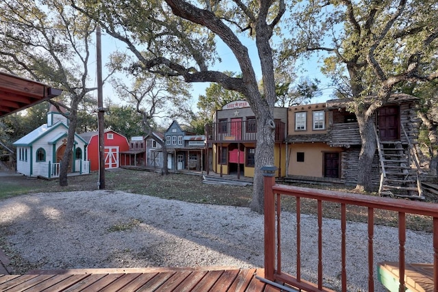 wooden deck featuring a barn, an outdoor structure, and stairs