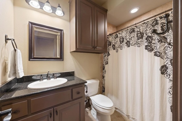 bathroom with curtained shower, toilet, and vanity