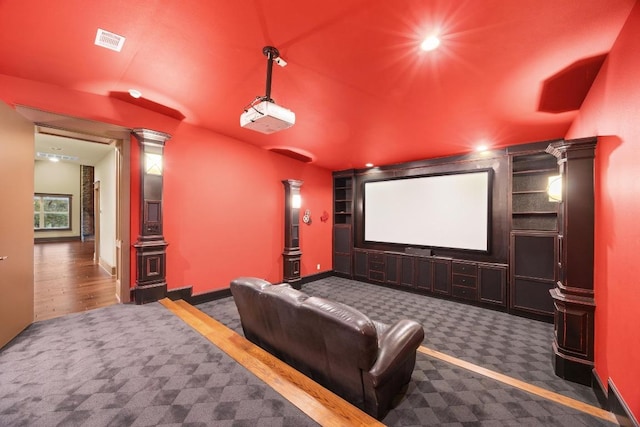 carpeted home theater with visible vents, built in features, recessed lighting, baseboards, and ornate columns