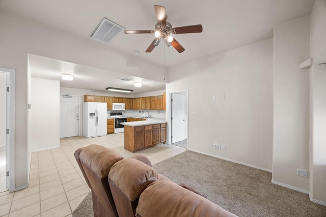 interior space with a ceiling fan, light tile patterned flooring, baseboards, and visible vents