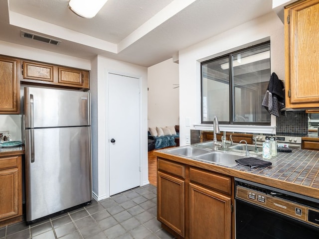 8200 Neely Dr Unit 251, Austin, TX 78759 - kitchen featuring freestanding refrigerator, a sink, tile patterned flooring, tile counters, and backsplash