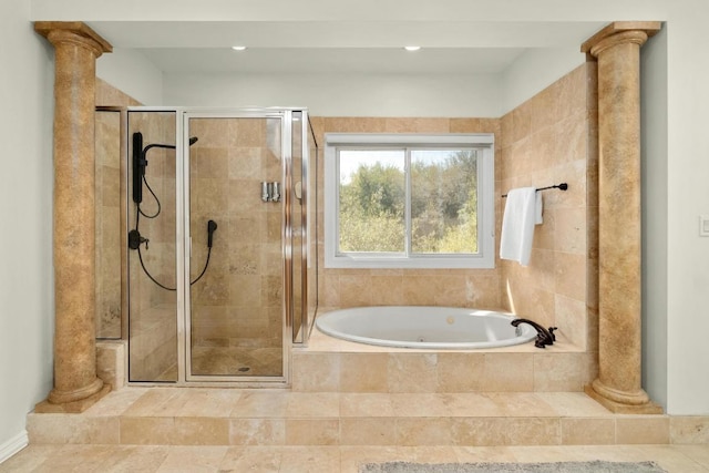 bathroom with a bath, a stall shower, and ornate columns