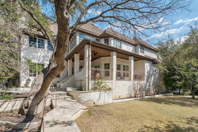 view of front of property featuring stucco siding, a porch, and a front yard