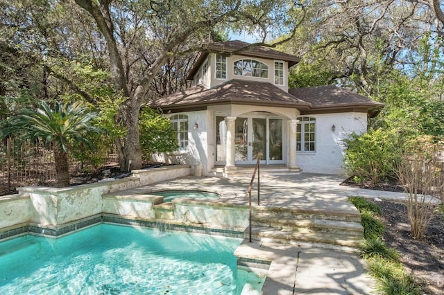 back of property featuring stucco siding, a patio, french doors, an outdoor pool, and an in ground hot tub