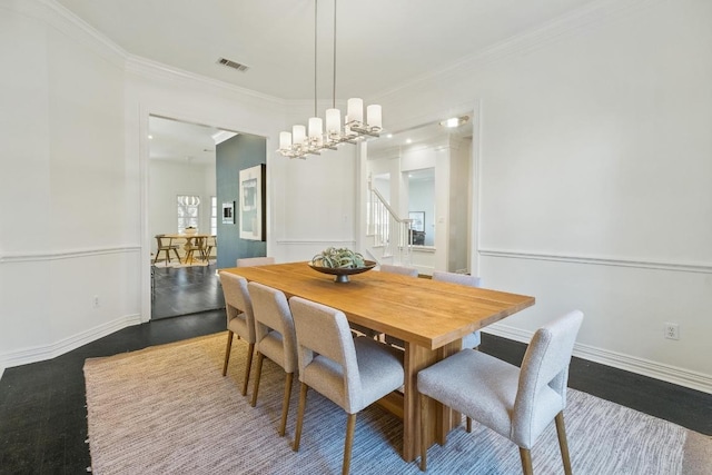 dining space featuring visible vents, crown molding, baseboards, and wood finished floors