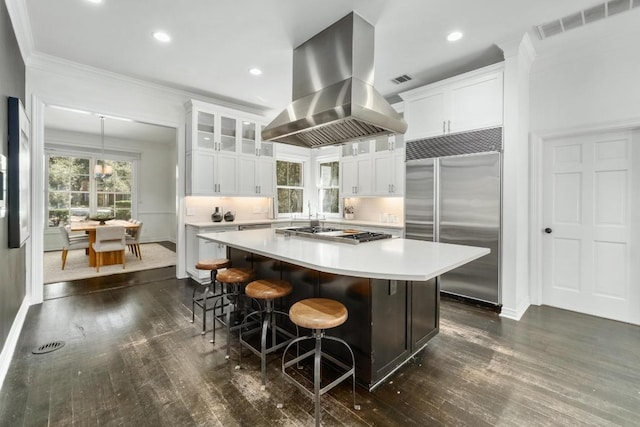 kitchen with visible vents, island exhaust hood, a center island, stainless steel appliances, and light countertops