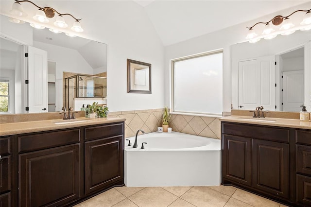 bathroom with tile patterned flooring, a shower stall, lofted ceiling, and a sink