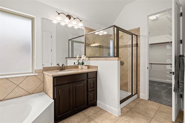 bathroom with tile patterned floors, a walk in closet, and a stall shower