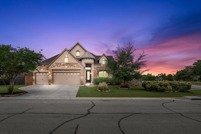 view of front of property featuring fence, concrete driveway, a front yard, stone siding, and an attached garage