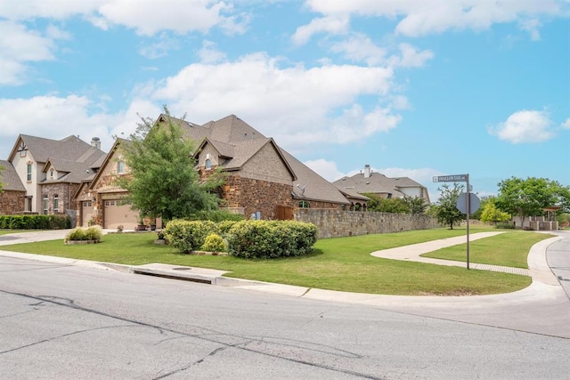 exterior space featuring stone siding, a residential view, and a yard