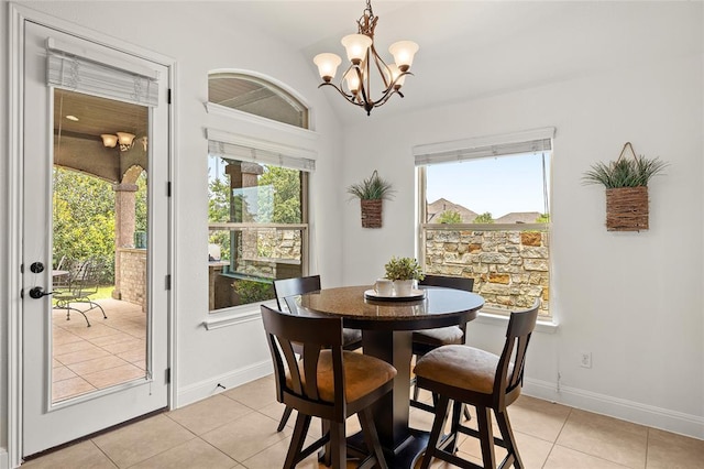 dining area featuring light tile patterned floors, baseboards, a healthy amount of sunlight, and a chandelier