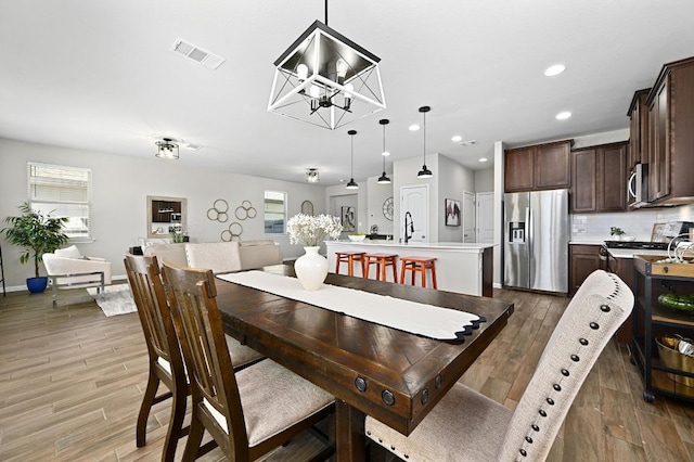 dining area featuring wood finished floors, visible vents, baseboards, an inviting chandelier, and recessed lighting