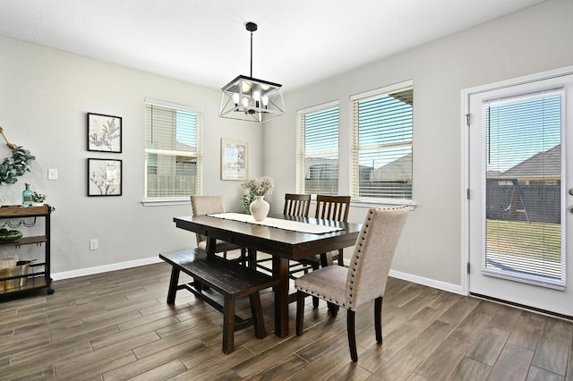 dining space featuring dark wood-style floors, a healthy amount of sunlight, and baseboards