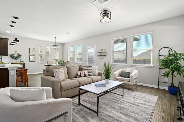 living area with dark wood finished floors, visible vents, and baseboards