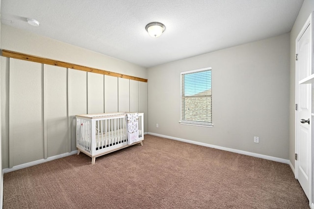 unfurnished bedroom featuring baseboards, carpet floors, and a textured ceiling