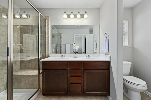 full bathroom with a shower stall, toilet, double vanity, and a sink